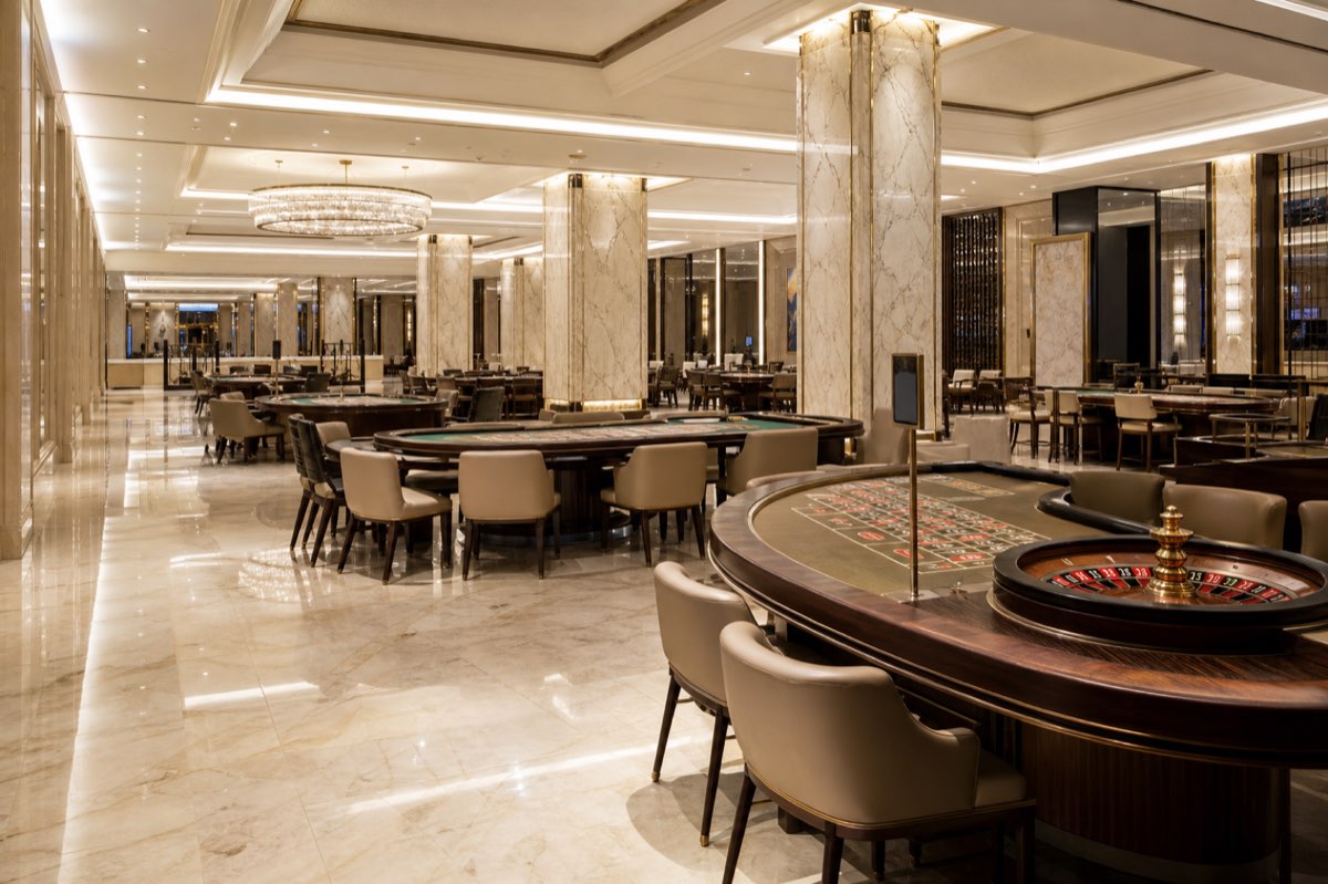 Roulette tables in an empty casino hall with marble columns